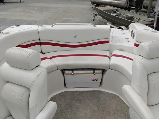 Slide: The Image of 2004 Sylvan 2240 Deck Boat interior with white and red seating, featuring a built-in cooler. - 16