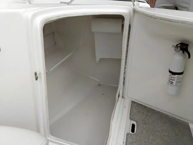 Slide: The Image of Open storage compartment on 2004 Sylvan 2240 Deck Boat with fire extinguisher. - 7