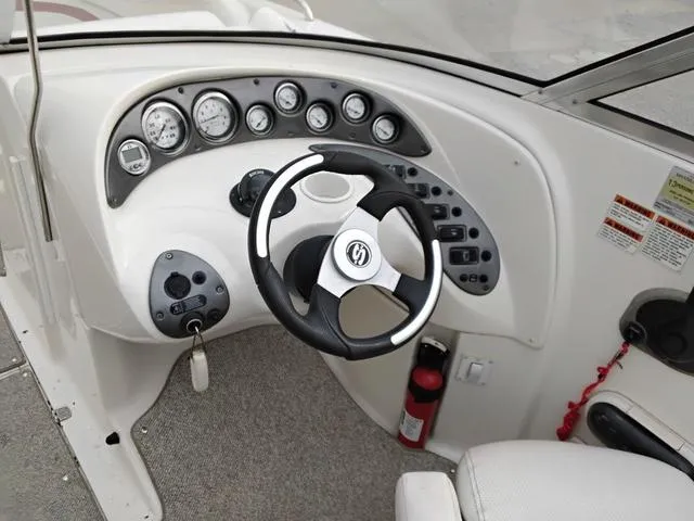Slide: The Image of 2004 Sylvan 2240 Deck Boat dashboard with steering wheel and instrument panel. - 9