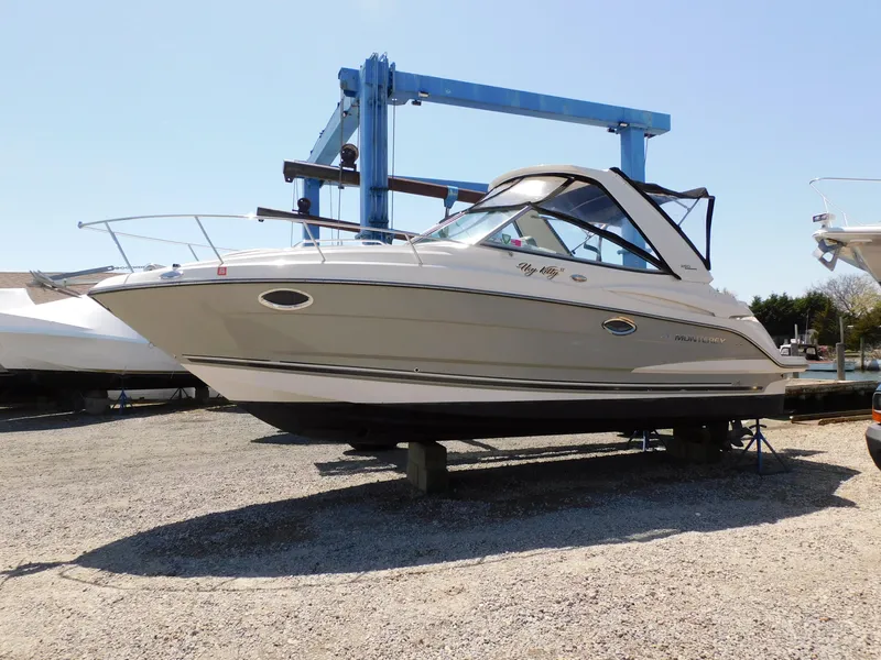 Slide: The Image of 2011 Monterey 260 SCR boat on dry dock, side view, with blue hoist in background. - 1