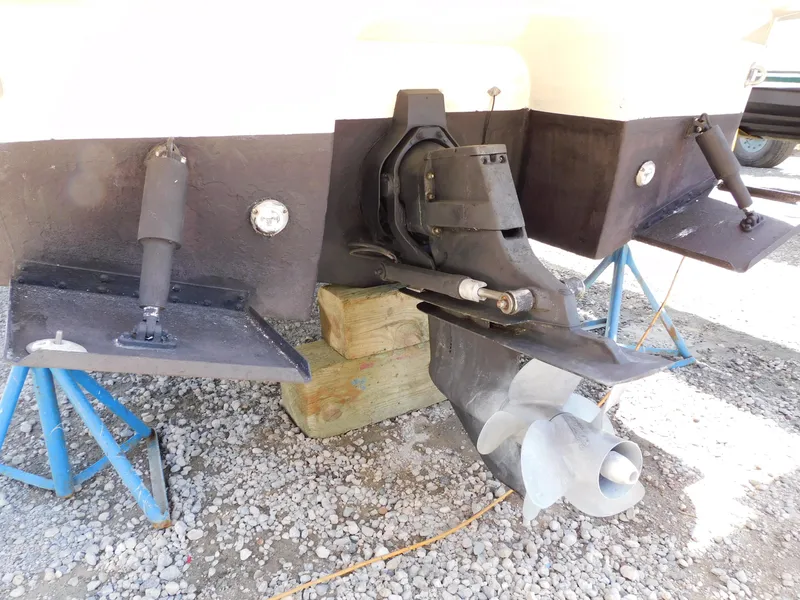 Slide: The Image of Rear view of a 2011 Monterey 260 SCR boat's propeller and trim tabs on gravel. - 12