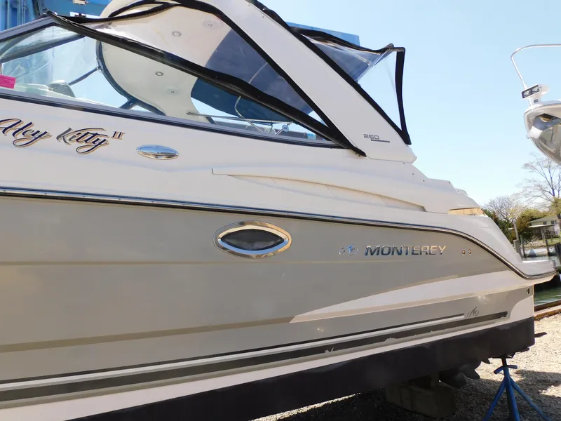 Slide: The Image of 2011 Monterey 260 SCR boat side view with sleek design and branding. - 20