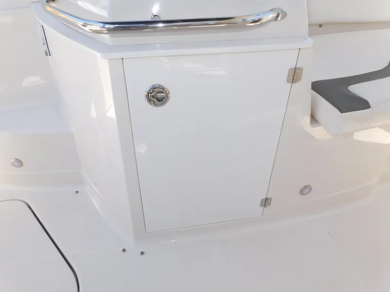 Slide: The Image of 2011 Monterey 260 SCR boat interior with white storage compartment and seating. - 41