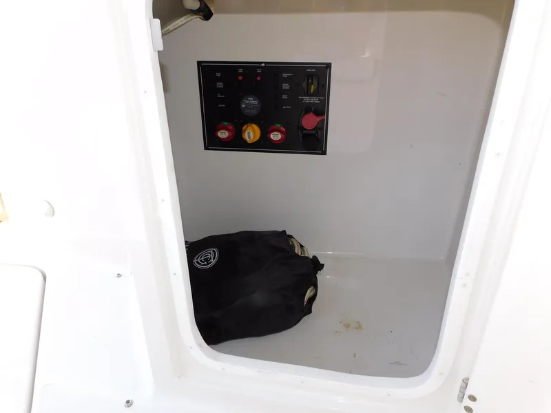 Slide: The Image of Electrical panel inside 2011 Monterey 260 SCR boat compartment with black bag on floor. - 42