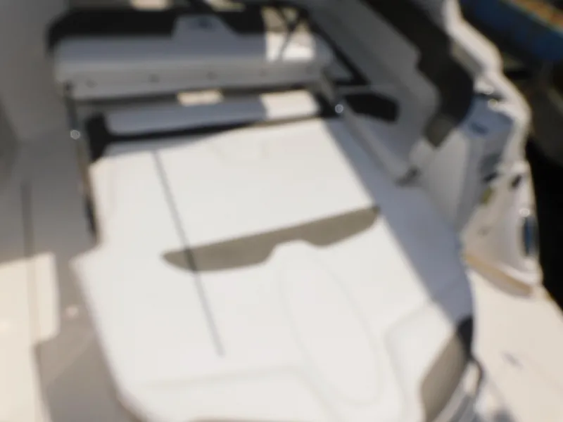 Slide: The Image of Blurry interior of a 2011 Monterey 260 SCR boat, featuring seating and deck area. - 51