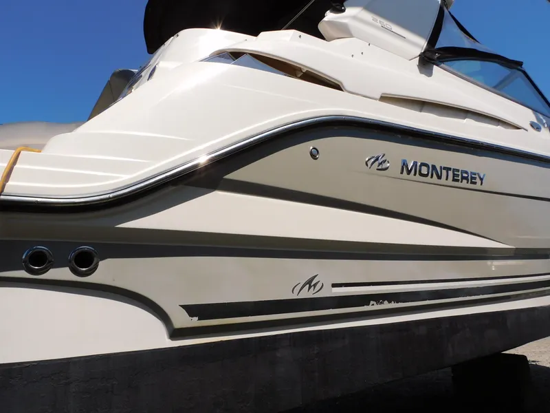 Slide: The Image of 2011 Monterey 260 SCR boat side view with logo, against clear blue sky. - 9