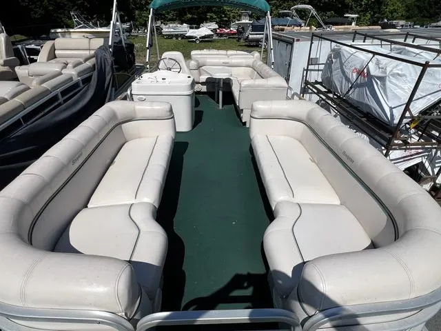 Slide: The Image of 1999 Sanpan 2500R pontoon boat with spacious seating and green carpeted deck. - 3
