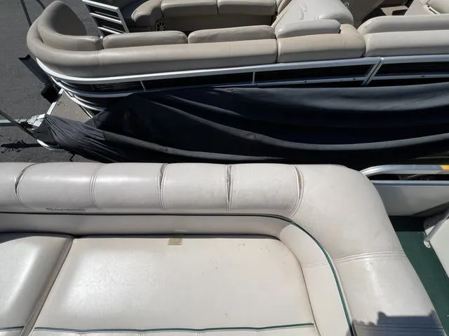 Slide: The Image of 1999 Sanpan 2500R pontoon boat with beige seating and protective cover. - 4