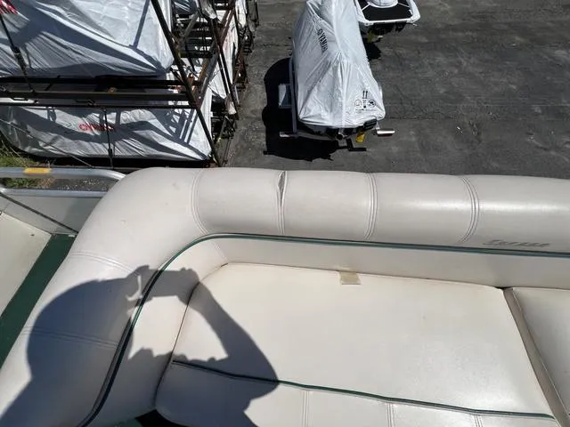 Slide: The Image of 1999 Sanpan 2500R boat seat with visible wear, surrounded by covered boats. - 6