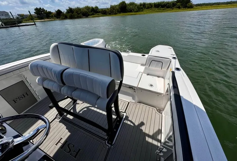 Slide: The Image of 2023 Yamaha Boats 255 FSH Sport E on water, featuring sleek seating and spacious deck. - 10