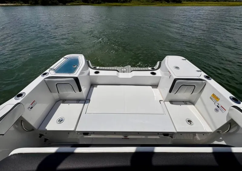 Slide: The Image of 2023 Yamaha Boats 255 FSH Sport E, spacious deck view on water. - 11