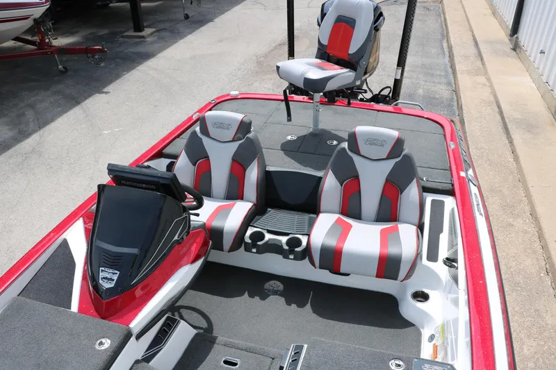 Slide: The Image of 2019 Skeeter FX20 boat interior with red and gray seating, steering console, and fishing chair. - 15