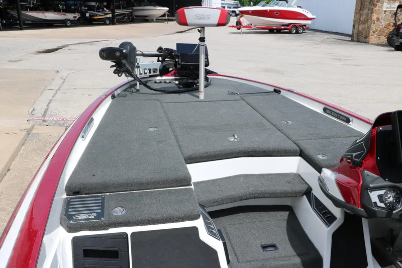 Slide: The Image of 2019 Skeeter FX20 bass boat with trolling motor and spacious deck, parked outdoors. - 20