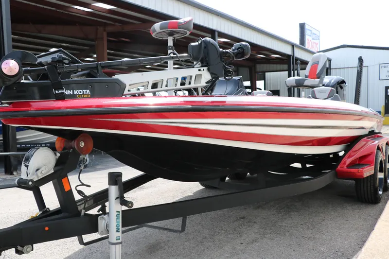 Slide: The Image of 2019 Skeeter FX20 bass boat with red and white detailing on a trailer. - 8