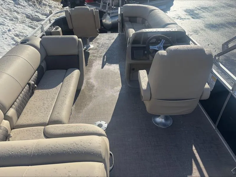 Slide: The Image of 2025 Sun Tracker SF 20 DLX pontoon boat interior with beige seating and steering console. - 10