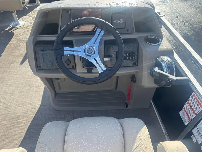 Slide: The Image of 2025 Sun Tracker SF 20 DLX boat dashboard with steering wheel and controls. - 2