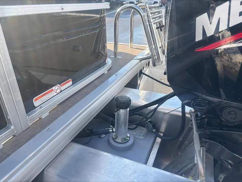 Slide: The Image of 2025 Sun Tracker SF 20 DLX boat with Mercury outboard motor, docked by water. - 5