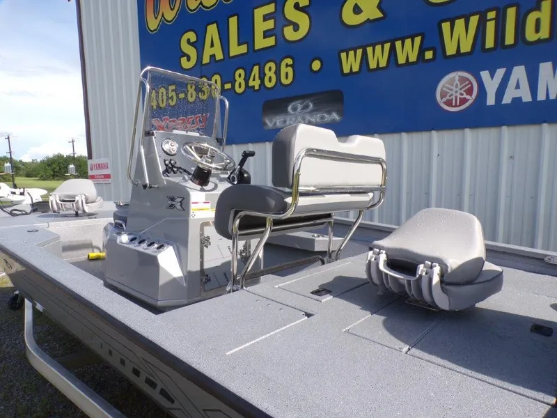 Slide: The Image of 2025 Xpress H20BAY boat with seating, console, and dealership signage in background. - 7