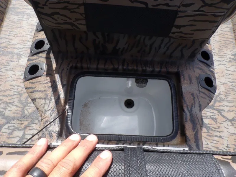 Slide: The Image of 2025 Xpress XP20CC boat storage compartment with camouflage design and cup holders. - 15