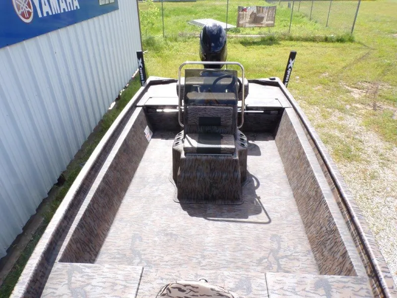 Slide: The Image of 2025 Xpress XP20CC boat with camouflage interior, parked outdoors near a Yamaha sign. - 18