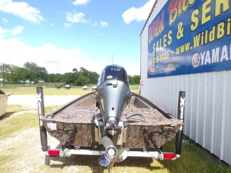 Slide: The Image of 2025 Xpress XP20CC boat with outboard motor at dealership, sunny day. - 2