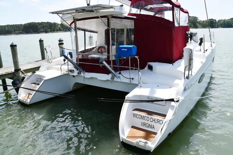 Slide: The Image of 2014 Fountaine Pajot Mahe 36 Evolution catamaran docked, featuring red canopy and Virginia registration. - 1