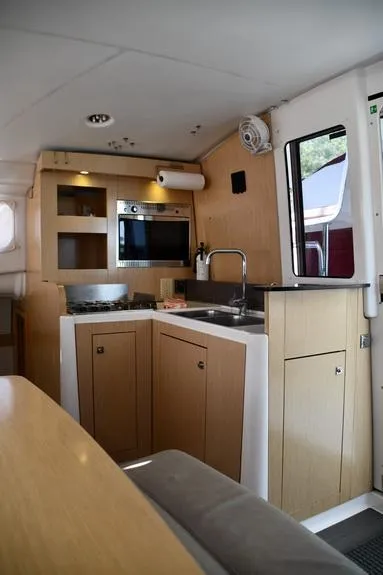 Slide: The Image of Interior of 2014 Fountaine Pajot Mahe 36 Evolution yacht, featuring a compact kitchen area. - 38