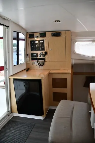 Slide: The Image of Interior of 2014 Fountaine Pajot Mahe 36 Evolution catamaran, featuring navigation controls and compact fridge. - 39