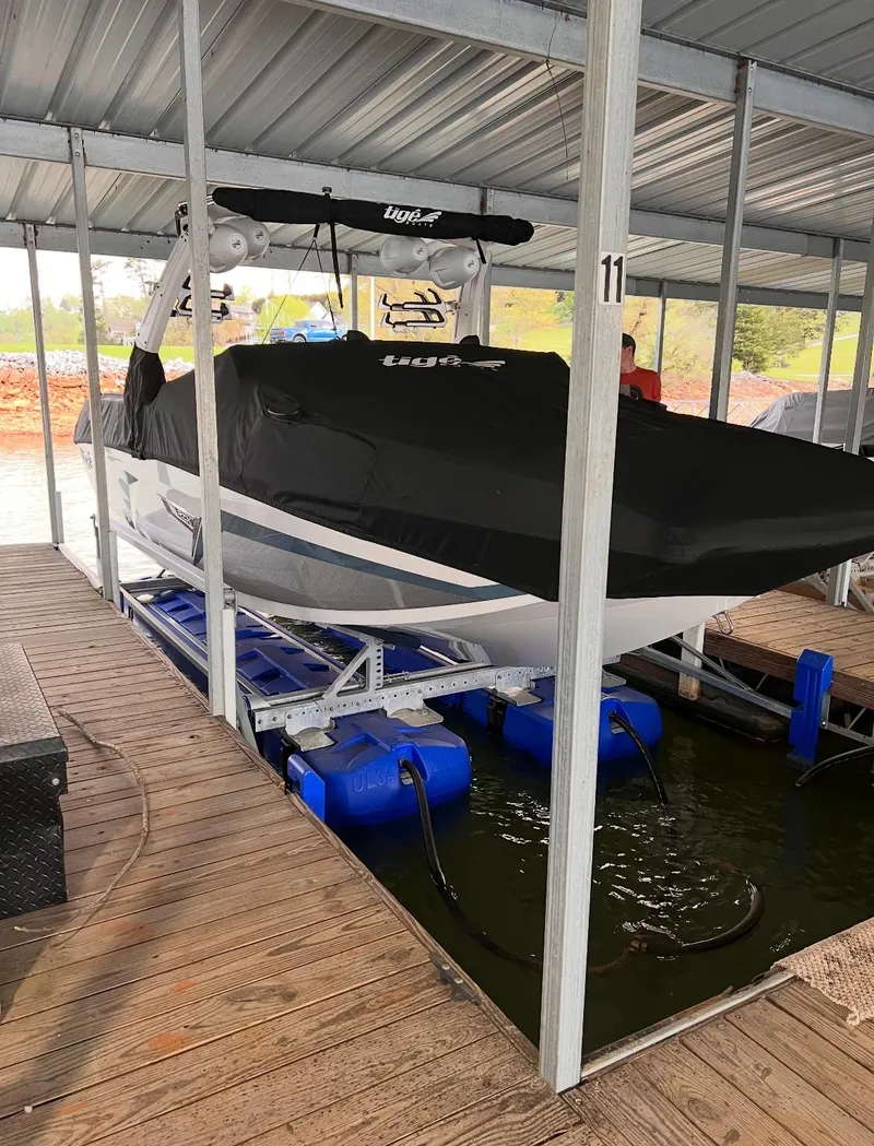 Slide: The Image of 2022 Tigé 24RZX boat covered and docked in a marina. - 12