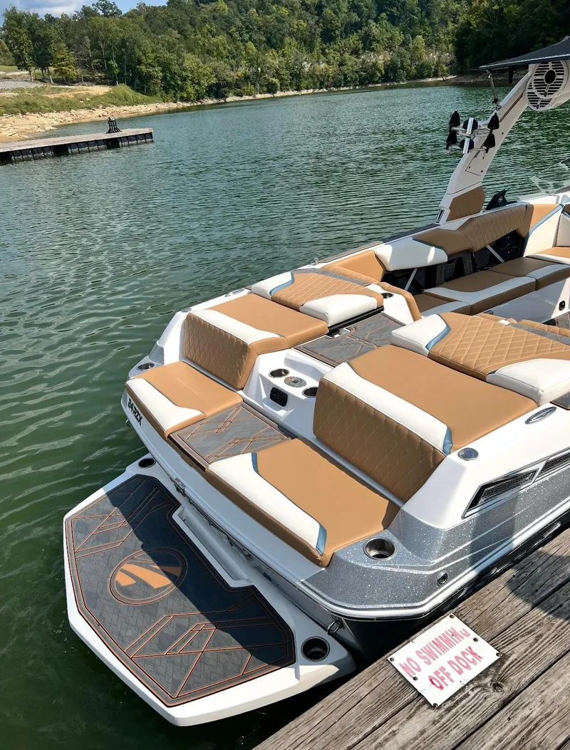 Slide: The Image of 2022 Tigé 24RZX boat docked on a serene lake with lush green surroundings. - 3