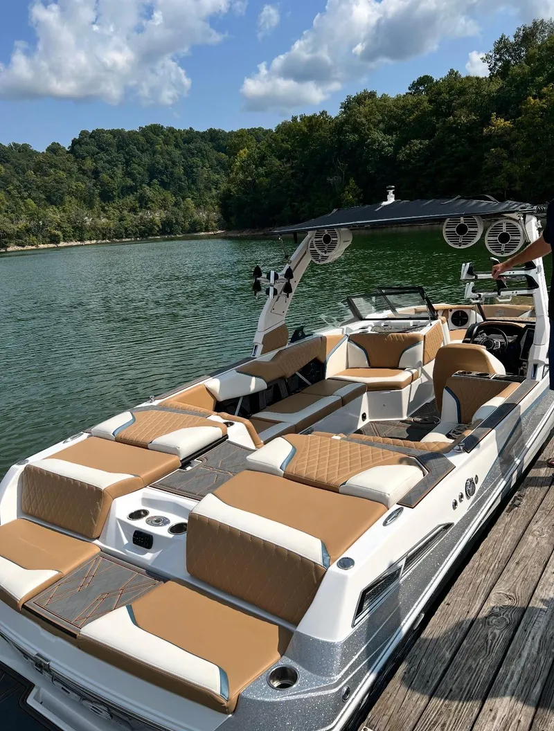 Slide: The Image of 2022 Tigé 24RZX boat docked on a serene lake with lush green surroundings. - 5