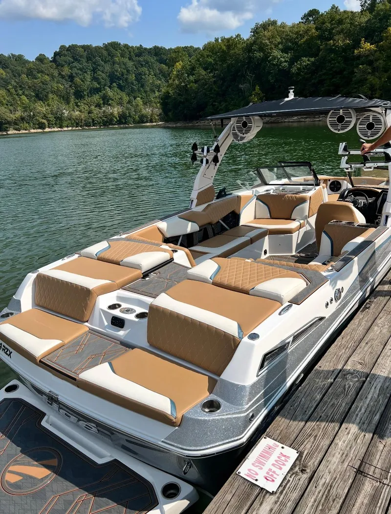 Slide: The Image of 2022 Tigé 24RZX boat docked on a scenic lake with lush greenery. - 6