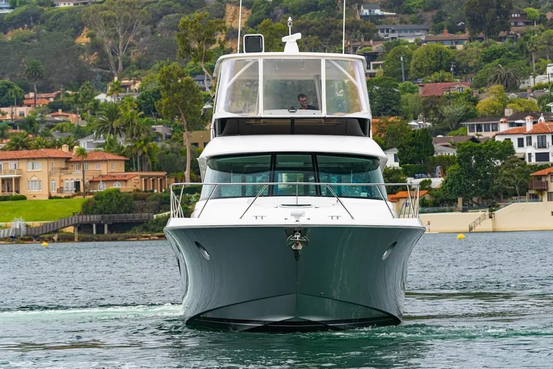 Slide: The Image of 2019 Tiara Yachts F 53 cruising on water with scenic coastal backdrop. - 10