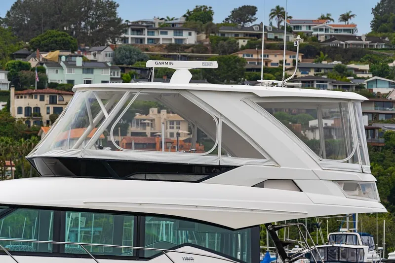 Slide: The Image of 2019 Tiara Yachts F 53 with modern design, docked near hillside homes. - 13