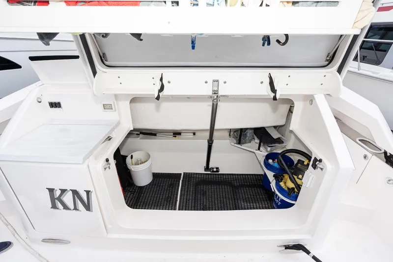 Slide: The Image of Open storage compartment on 2019 Tiara Yachts F 53, featuring cleaning supplies and equipment. - 27