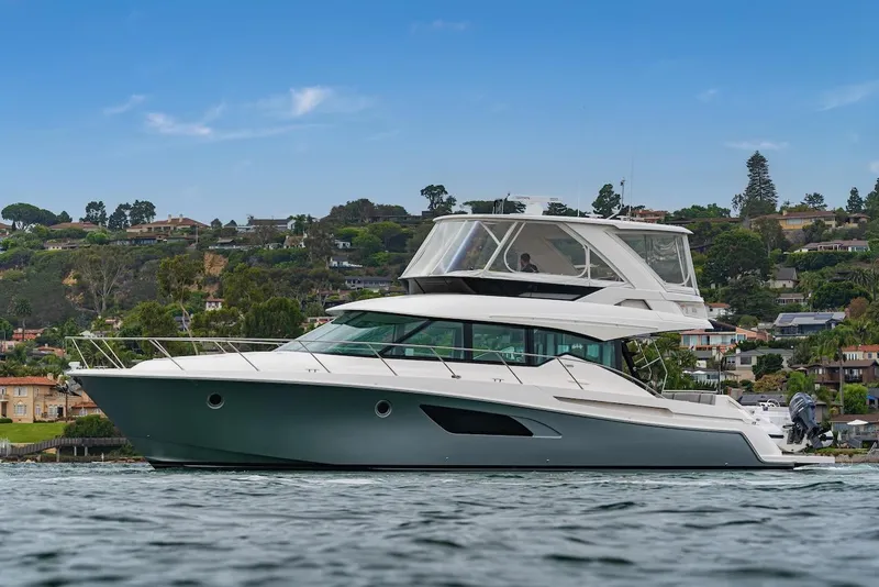 Slide: The Image of 2019 Tiara Yachts F 53 cruising on a scenic waterfront. - 5