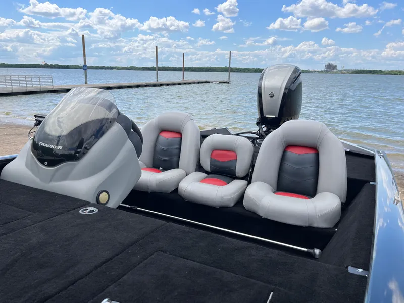 Slide: The Image of 2016 Tracker Pro Team 175 TXW boat with gray and red seats by a lake. - 16