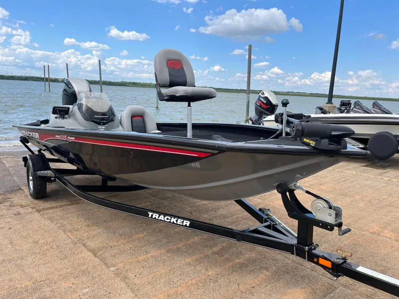 Slide: The Image of 2016 Tracker Pro Team 175 TXW boat on trailer by a lake under blue sky. - 3