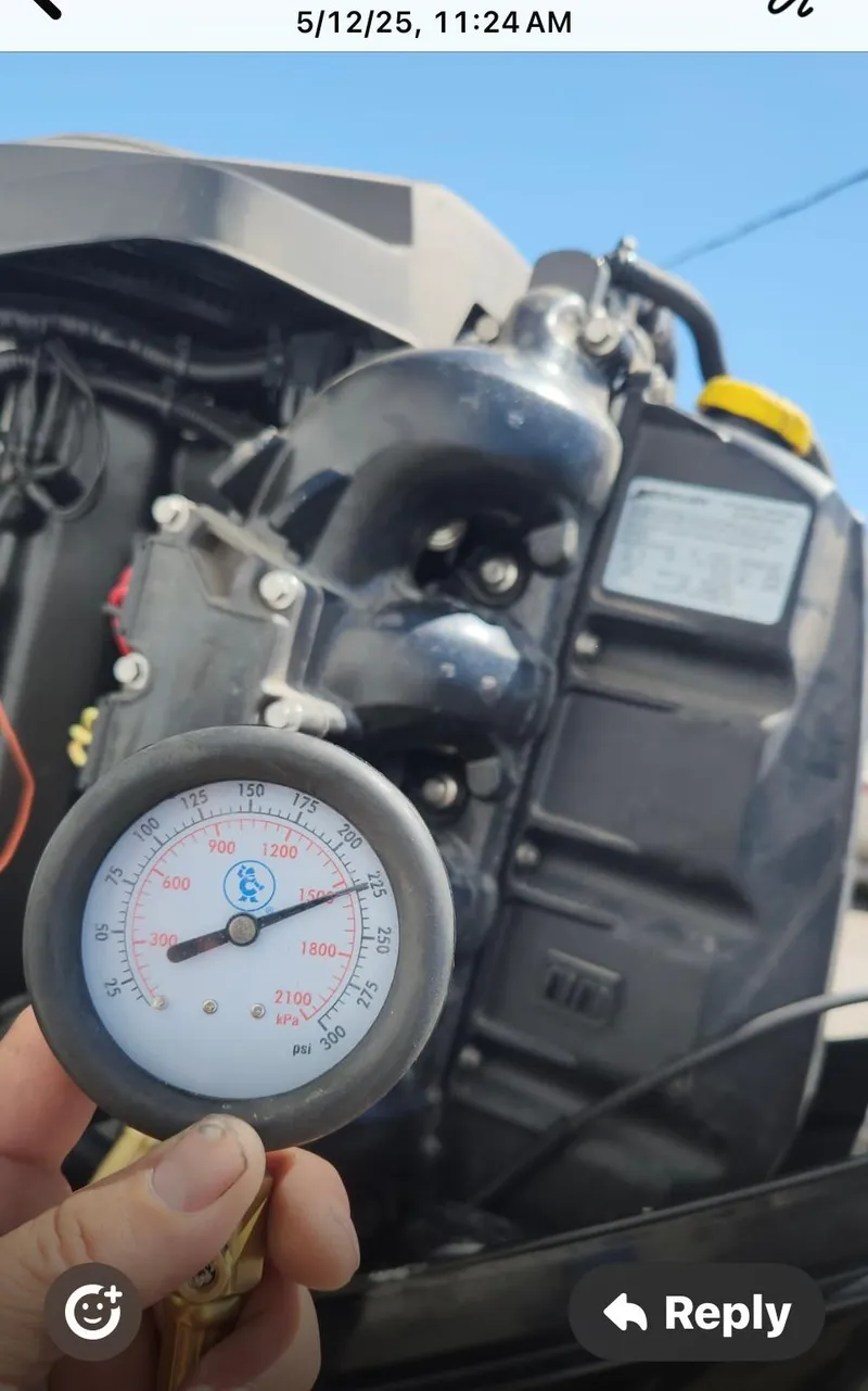 Slide: The Image of Hand holding a pressure gauge near a 2016 Tracker Pro Team 175 TXW engine. - 38