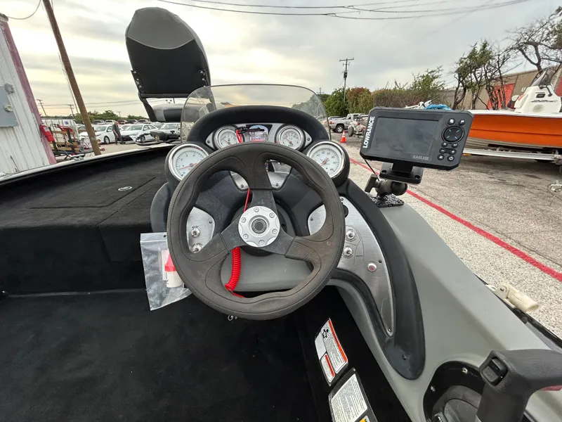 Slide: The Image of 2016 Tracker Pro Team 175 TXW boat dashboard with steering wheel and mounted device. - 48