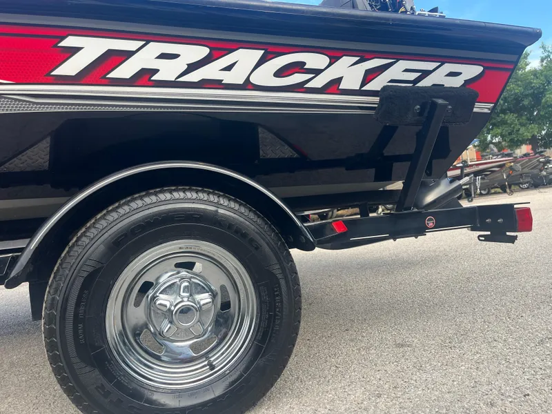 Slide: The Image of 2016 Tracker Pro Team 175 boat trailer with chrome wheel on pavement. - 58