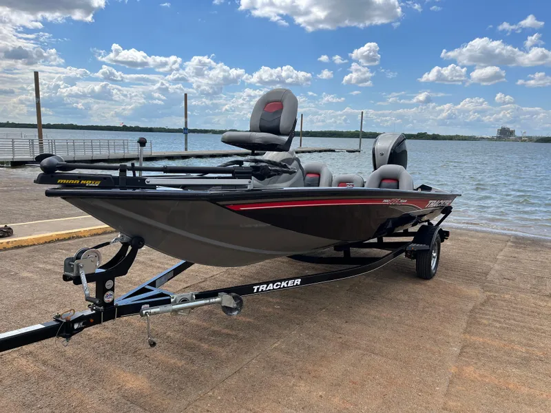 Slide: The Image of 2016 Tracker Pro Team 175 TXW boat on trailer by a lake under a blue sky. - 6