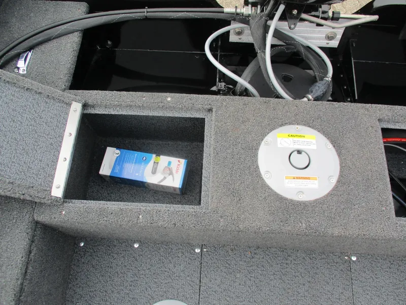 Slide: The Image of 2025 Lund Rebel XL 1650 SS boat storage compartment with a packaged item inside. - 6