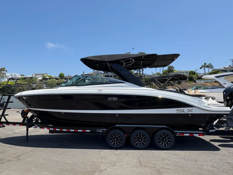 The Image of 2026 Sea Ray SLX 280 boat on trailer, sleek black and white design, sunny day. - 0