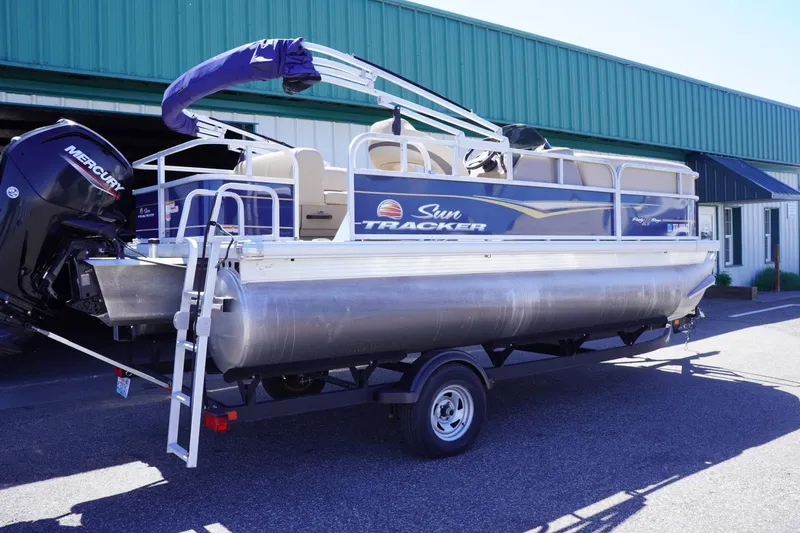 Slide: The Image of 2022 Sun Tracker Party Barge 18 DLX pontoon boat on trailer, parked outdoors. - 12