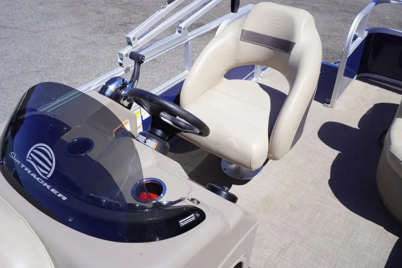 Slide: The Image of 2022 Sun Tracker Party Barge 18 DLX helm with beige captain's chair and steering wheel. - 17
