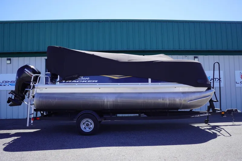 Slide: The Image of 2022 Sun Tracker Party Barge 18 DLX pontoon boat with cover, parked on trailer. - 43