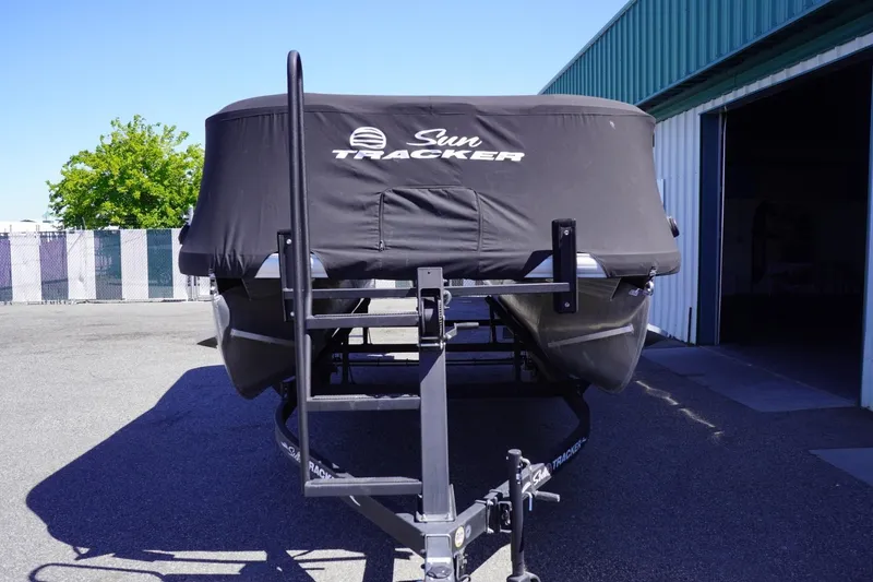 Slide: The Image of 2022 Sun Tracker Party Barge 18 DLX covered on trailer, parked outdoors. - 45