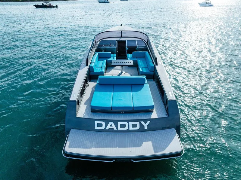 Slide: The Image of VanDutch 55 yacht, 2015 model, with blue seating, named "DADDY," on calm water. - 11