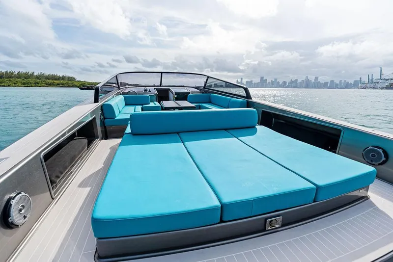 Slide: The Image of Luxurious 2015 VanDutch 55 yacht with spacious turquoise seating, cruising near a city skyline. - 21